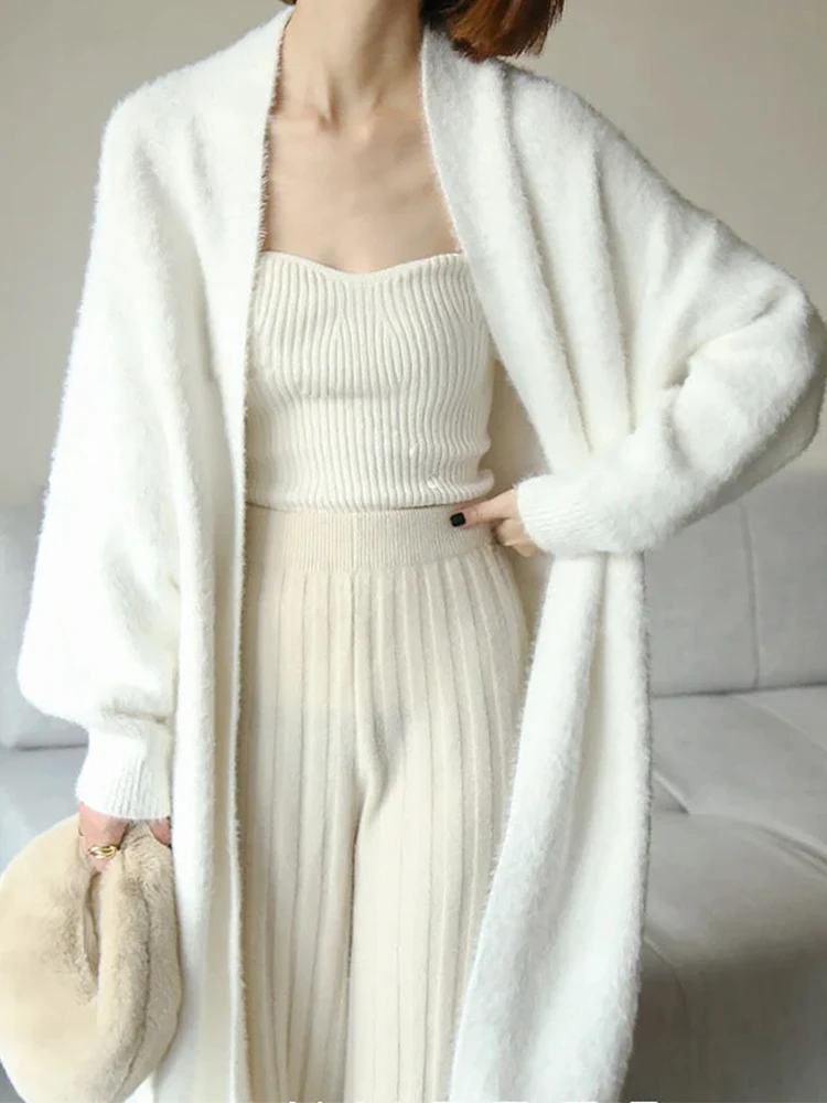 Luxurious layering with a long cashmere cardigan over denim for balanced proportions